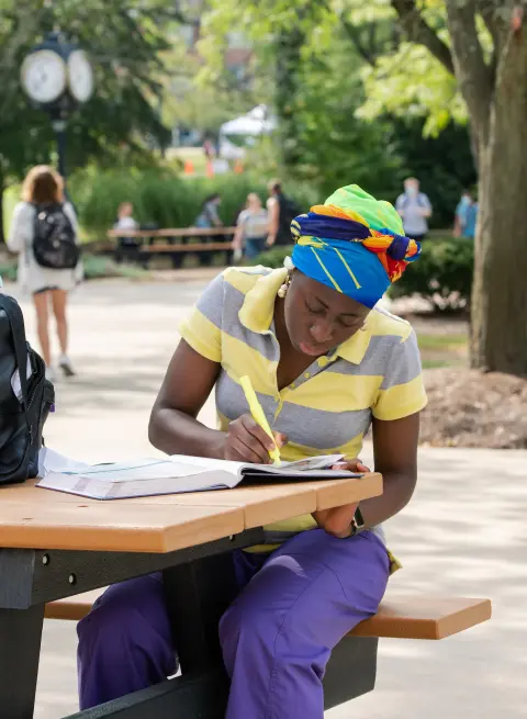 Female student highlighting something in a notebook